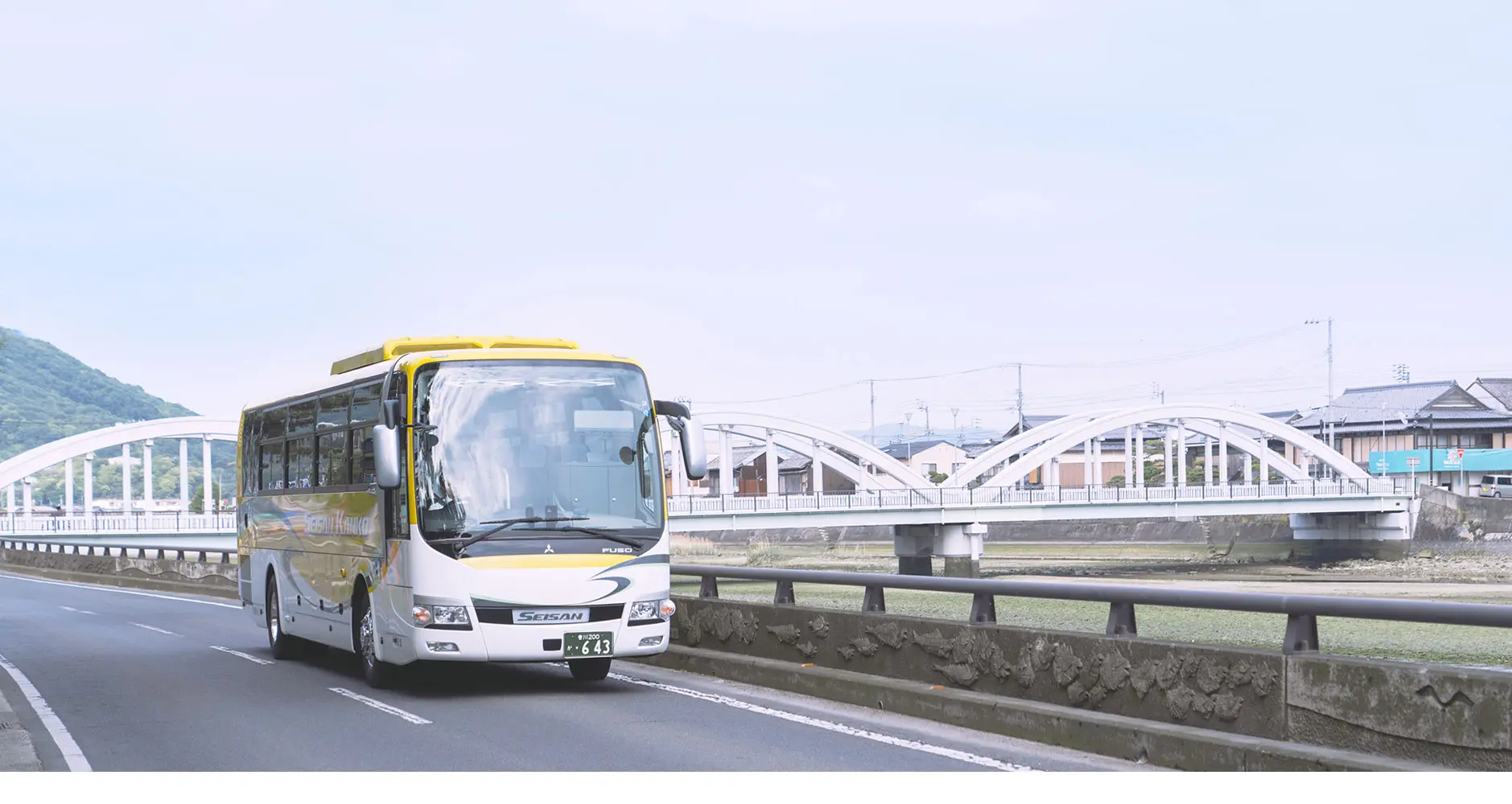 橋のそばを走る西讃観光の貸切バス
